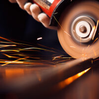 Red hot sparks at grinding steel material. Close up